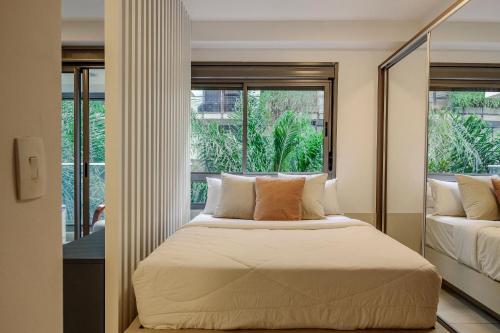 a bedroom with a bed and a large window at Vossa Bossa Vila Madalena in São Paulo