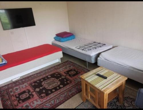 a small room with two beds and a coffee table at One Large Room with 3 single beds in Gothenburg