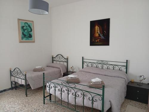 a bedroom with two beds and a picture on the wall at La Casa di Anna in Sassari