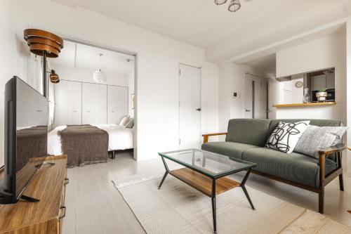a living room with a couch and a table at Cozy Stay Sapporo Maruyama Ibiza in Sapporo