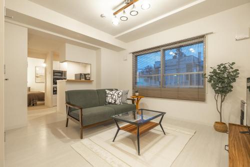 a living room with a couch and a table at Cozy Stay Sapporo Maruyama Ibiza in Sapporo