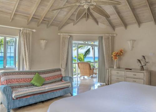 a living room with a ceiling fan and a couch at Ebbtide villa in Saint James