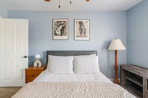 a bedroom with a bed and two pictures on the wall at Historic Belmont Home - Steps to Stowe Manor and Downtown in Belmont