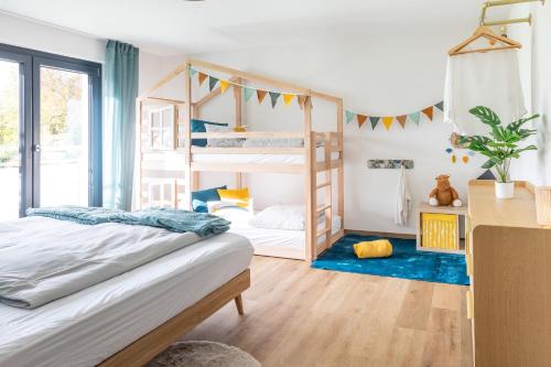 a bedroom with two bunk beds and a blue rug at Heimbi-Home No 3, 4-6 Pers, EuropaPark, E-Ladesäule in Kappel-Grafenhausen