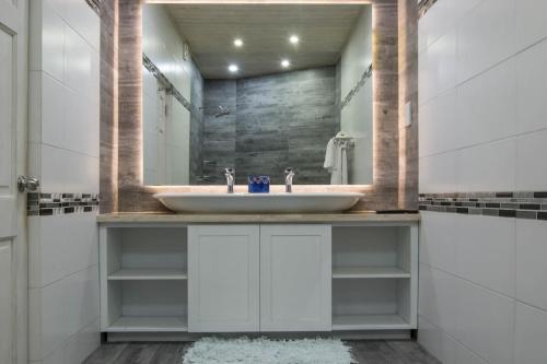a bathroom with a sink and a mirror at Ebbtide villa in Saint James