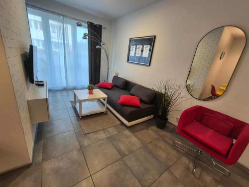 a living room with a couch and a mirror at Mieszkanie z tarasem - Rybacka in Władysławowo