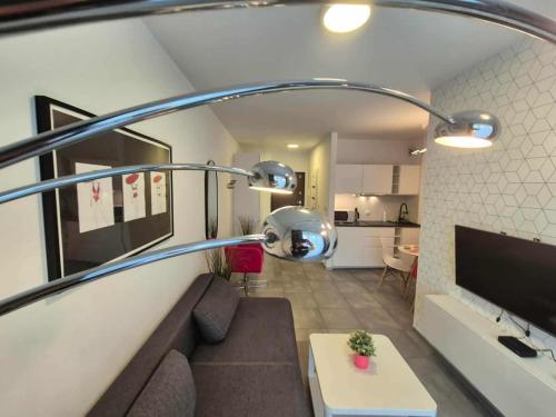 a living room with a couch and a tv and a kitchen at Mieszkanie z tarasem - Rybacka in Władysławowo