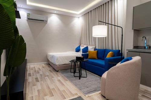 a bedroom with a blue couch and a bed at A distinctive and upscale studio in Salamanca 112 in Riyadh
