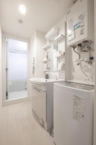 a white kitchen with a sink and a refrigerator at Cozy Stay Sapporo Maruyama Ibiza in Sapporo