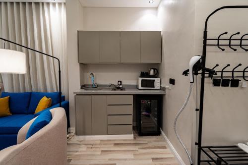 a small kitchen with a blue couch in a room at A distinctive and upscale studio in Salamanca 112 in Riyadh