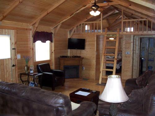 a living room with a leather couch and a tv at Mammoth Cave Accommodation for a Kentucky Glamping Experience in Mammoth Cave