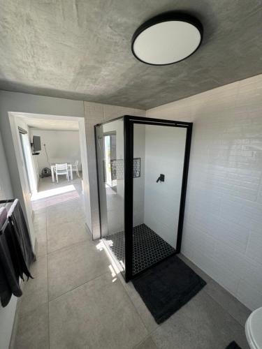 a bathroom with a walk in shower with a mirror at Protea32 in Agulhas