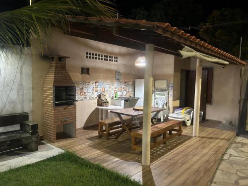 eine Holzterrasse mit einem Tisch und einem Kamin in der Unterkunft casa temporada praia de sonho verde, Paripueira - Alagoas in Paripueira
