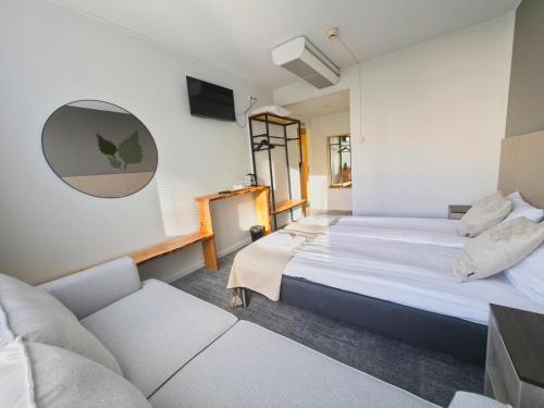 a bedroom with two beds and a couch at Hotelli Savonlinna in Savonlinna
