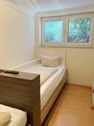 a small room with a bed and two windows at Lounge 04 in Norderney
