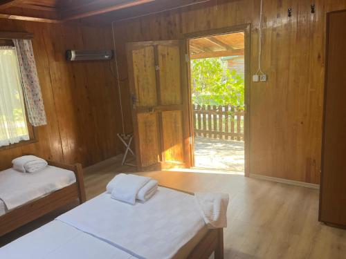 a room with two beds and a sliding glass door at Kybele Nature Life in Edremit