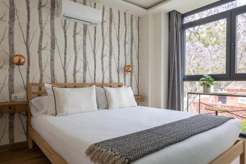 マラガにあるBe Mate Málaga Playaのベッドと窓のある寝室