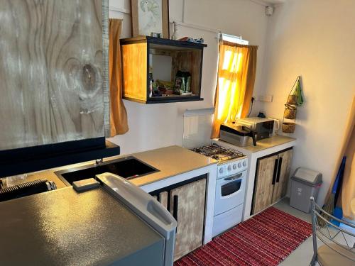 eine kleine Küche mit Herd und Spüle in der Unterkunft Apartment in Montagne Charlot with stunning view of the lagoon in Saint Gabriel