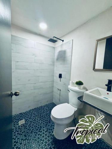 a bathroom with a white toilet and a sink at Hotel Tropical in Villahermosa