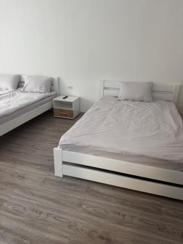 a bedroom with two beds and a wooden floor at YarNika in Berehove