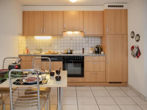 a kitchen with wooden cabinets and a counter top at Apartment Réze 5 by Interhome in Ovronnaz