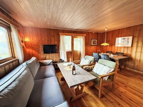 ein Wohnzimmer mit Sofa und Tisch in der Unterkunft Holiday Home Turken by Interhome in Kaupanger
