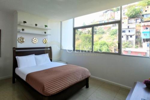 a bedroom with a bed and a large window at EcuOlimpo Lighthouse Stay double in Guayaquil