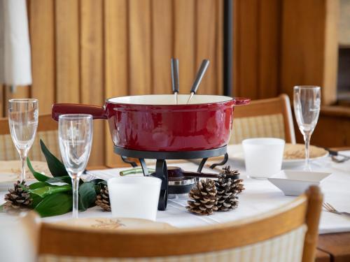 uma panela vermelha sobre uma mesa com taças de vinho em Apartment Val Neige 11 by Interhome em Verbier