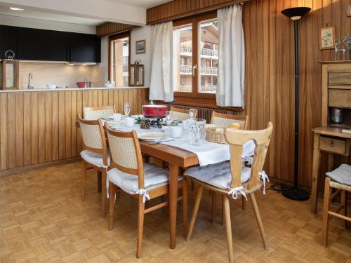 uma sala de jantar com mesa e cadeiras de madeira em Apartment Val Neige 11 by Interhome em Verbier