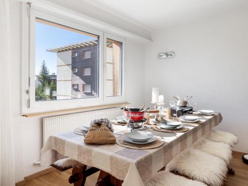a table with plates and dishes on it in a room with a window at Apartment Vermala Soleil B1 by Interhome in Vermala