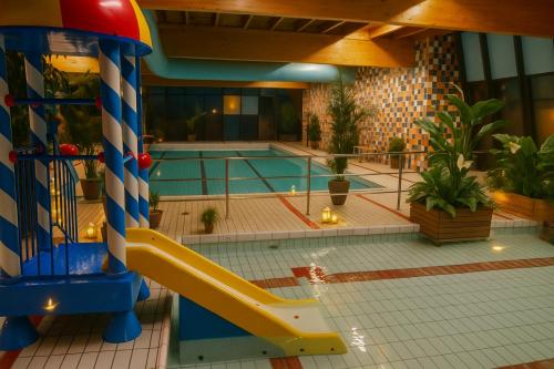 a swimming pool with a slide in a building at Premium-Strand Chalet an der Nordsee - Noordzee - Zeeland in Breskens