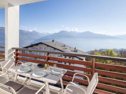 a table and chairs on a balcony with a view of mountains at Apartment Armorial Est 72 by Interhome in Vermala