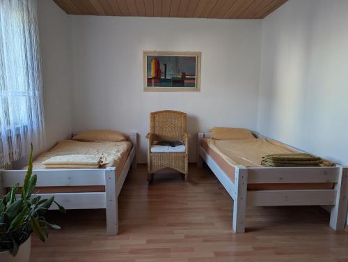 a bedroom with two beds and a chair at Ferienwohnung Lygri in Olpe