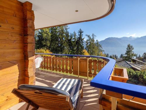a balcony with a blue railing and chairs on a deck at Apartment Résidence Le Chalet 5 by Interhome in Crans-Montana