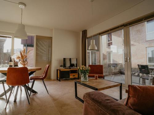 ein Wohnzimmer mit Sofa und Tisch in der Unterkunft Holiday Home De Zeeparel by Interhome in Egmond aan Zee