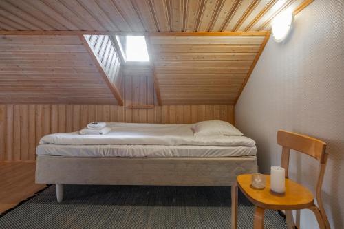 a small bedroom with a bed in a attic at Koda Halo Lodge - Sauna, Parking & Playstation in Rovaniemi