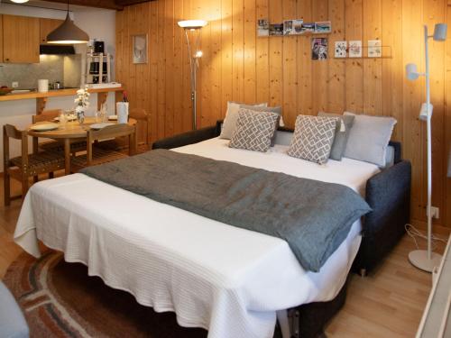 a bedroom with a bed and a table and a kitchen at Apartment Parc C013 by Interhome in Champex