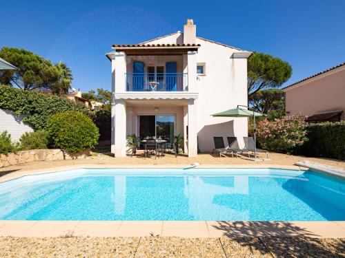 a villa with a swimming pool in front of a house at Holiday Home Le Mas d'Esquières 7 by Interhome in Les Issambres