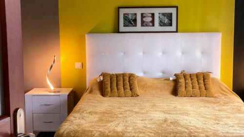 a bedroom with a large bed with a white headboard at Chambre MELUSINE in Néant-sur-Yvel