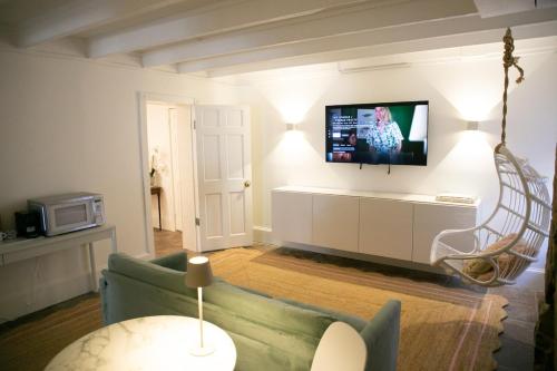 a living room with a couch and a tv on a wall at Bosch House Rosé - Garden Suite in Savannah