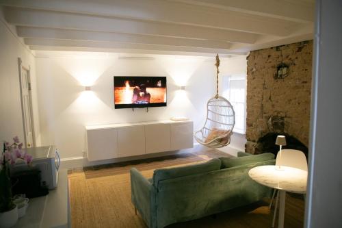a living room with a green couch and a tv at Bosch House Rosé - Garden Suite in Savannah