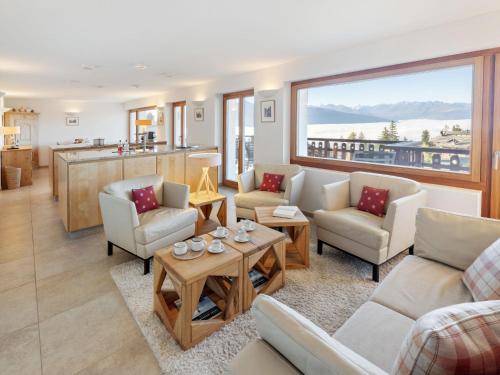 a living room with a couch and chairs and a table at Apartment Les Aiguilles Vertes Rez inférieur by Interhome in Crans-Montana