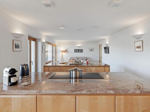 a large kitchen with a counter top and a kitchen island at Apartment Les Aiguilles Vertes Rez inférieur by Interhome in Crans-Montana