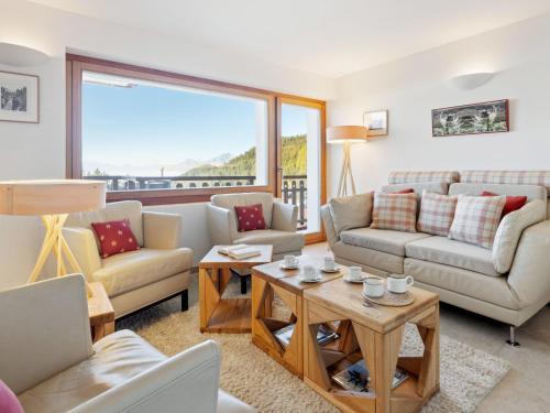 a living room with couches and a table at Apartment Les Aiguilles Vertes Rez inférieur by Interhome in Crans-Montana