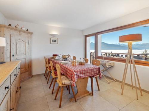 a dining room with a table and chairs and a window at Apartment Les Aiguilles Vertes Rez inférieur by Interhome in Crans-Montana