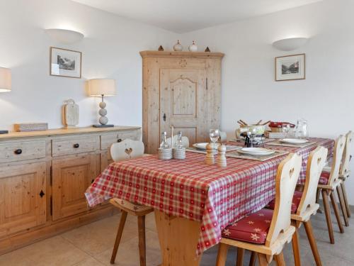 een keuken met een tafel met een rode en witte tafeldoek bij Apartment Les Aiguilles Vertes Rez inférieur by Interhome in Crans-Montana