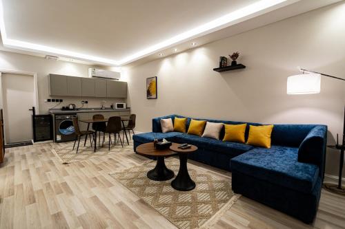 a living room with a blue couch and a table at Spacious room and hall in Sulaymaniyah 309 in Riyadh