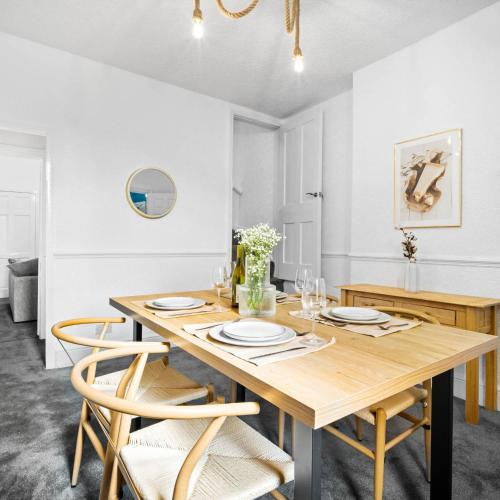 a dining room with a wooden table and chairs at Stylish Three Bed House - Parking - Garden - Netflix 17ML in Birmingham