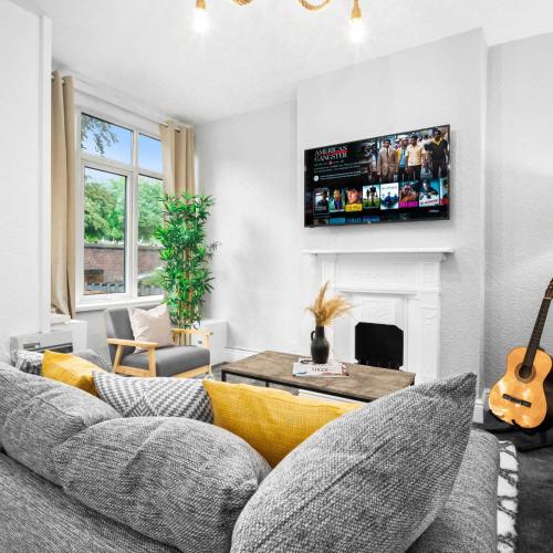 a living room with a couch and a tv at Stylish Three Bed House - Parking - Garden - Netflix 17ML in Birmingham