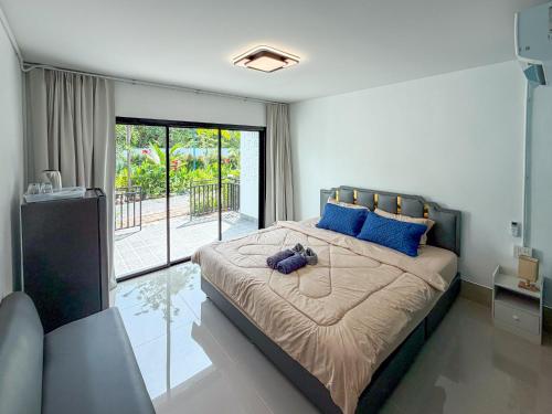 ランタ島にあるThawat Villa Boutique Resortの青い枕が付いた大きなベッドのある寝室